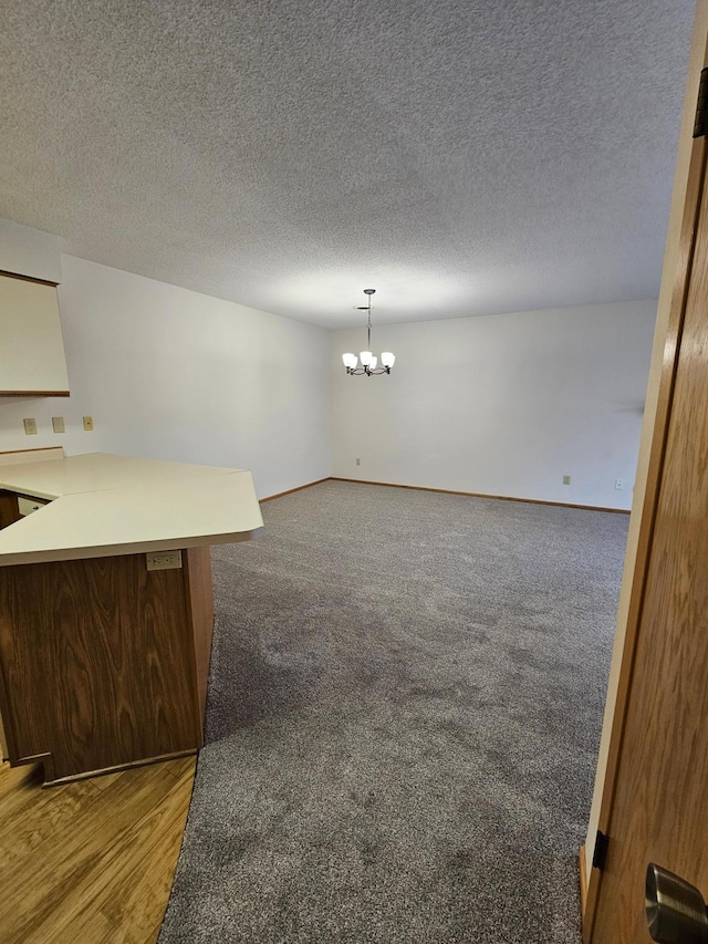 21965 Shady Walk Unit 201, Deerwood, MN 56444 - unfurnished living room with baseboards, a textured ceiling, and a chandelier