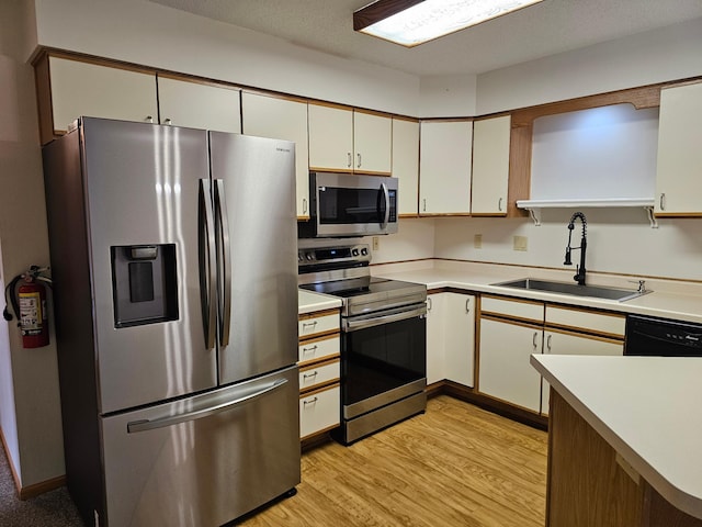 21965 Shady Walk Unit 201, Deerwood, MN 56444 - kitchen featuring stainless steel appliances, light wood-type flooring, light countertops, and white cabinetry