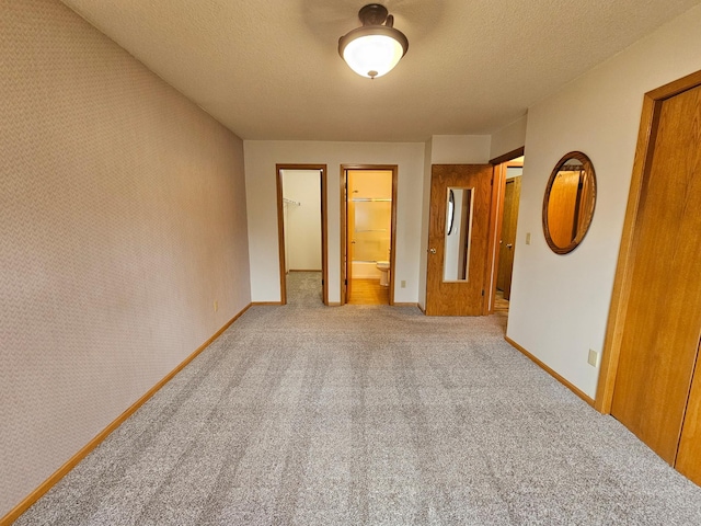 21965 Shady Walk Unit 201, Deerwood, MN 56444 - unfurnished bedroom with carpet, a textured ceiling, a spacious closet, a closet, and ensuite bathroom
