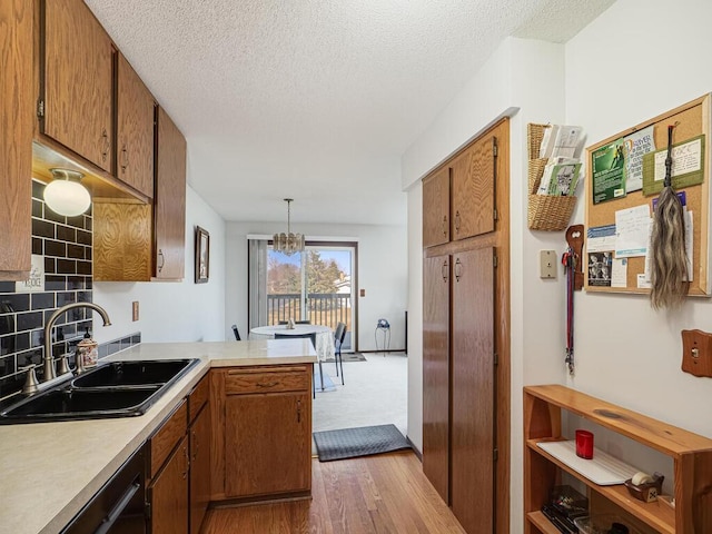 15722 Griffon Ct, Apple Valley, MN 55124 - kitchen featuring a sink, a peninsula, dark wood-style floors, dishwasher, and light countertops