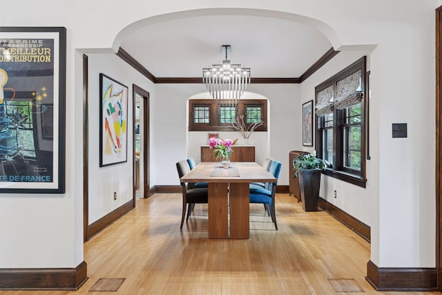 1295 Fairmount Ave, Saint Paul, MN 55105 - dining area featuring light wood finished floors, ornamental molding, arched walkways, and a chandelier