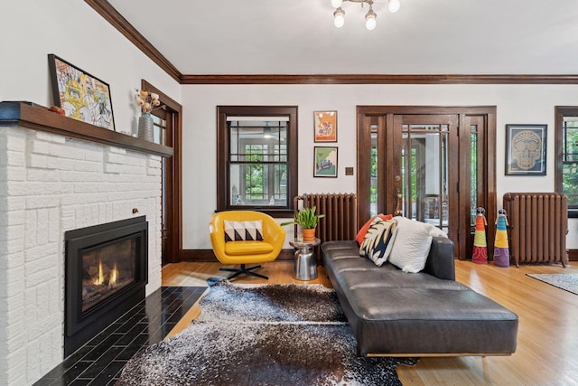 1295 Fairmount Ave, Saint Paul, MN 55105 - living room featuring radiator, wood finished floors, ornamental molding, and a brick fireplace