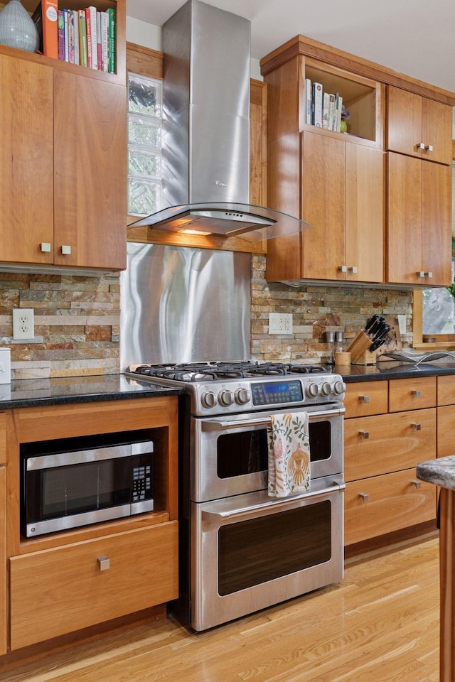 1295 Fairmount Ave, Saint Paul, MN 55105 - kitchen with wall chimney exhaust hood, stainless steel appliances, light wood-style floors, backsplash, and brown cabinetry
