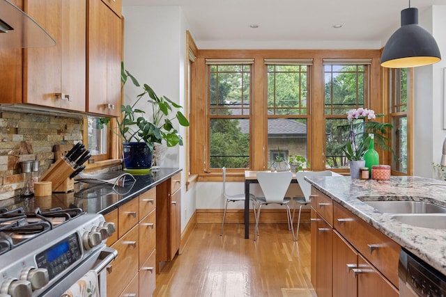 1295 Fairmount Ave, Saint Paul, MN 55105 - kitchen with stainless steel appliances, light wood-style flooring, brown cabinets, light stone countertops, and recessed lighting