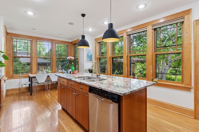 1295 Fairmount Ave, Saint Paul, MN 55105 - kitchen with stainless steel dishwasher, light wood-type flooring, light stone countertops, an island with sink, and hanging light fixtures