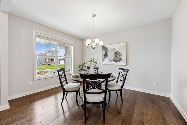 dining area with baseboards, a notable chandelier, and dark wood-type flooring
