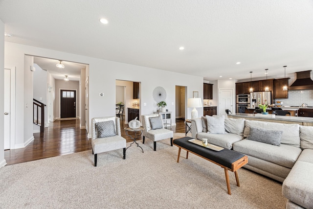 carpeted living room featuring recessed lighting, baseboards, stairs, and wood finished floors