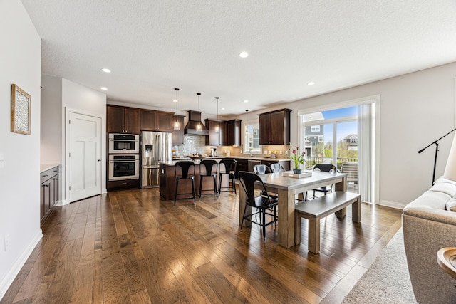 dining area featuring dark wood-type flooring, recessed lighting, and baseboards