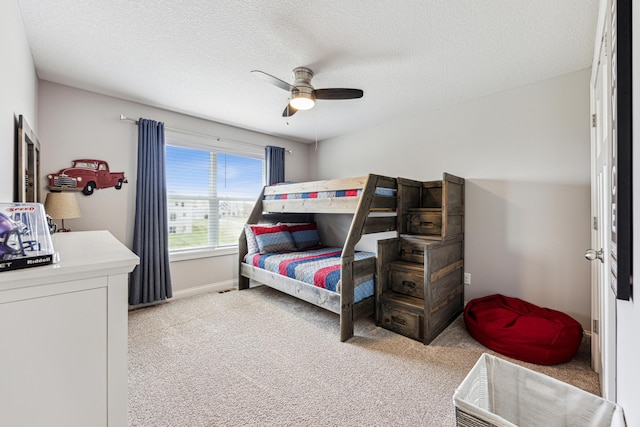 bedroom with baseboards, ceiling fan, a textured ceiling, and light colored carpet