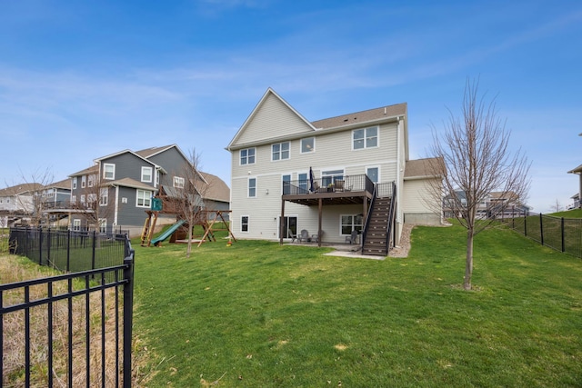 back of property featuring a deck, a fenced backyard, a playground, a yard, and stairs