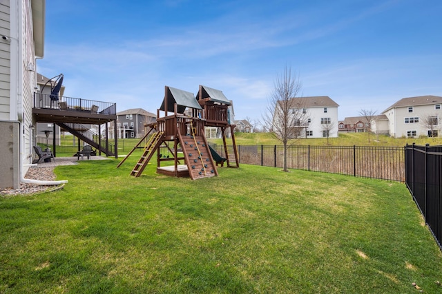 view of play area with a lawn, a fenced backyard, stairs, and a residential view