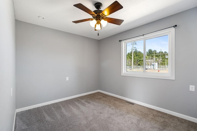 carpeted empty room featuring ceiling fan, baseboards, and visible vents