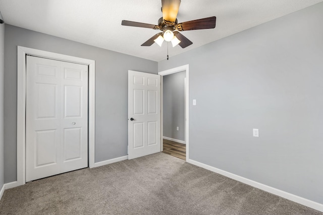 unfurnished bedroom featuring carpet floors, a closet, a ceiling fan, and baseboards