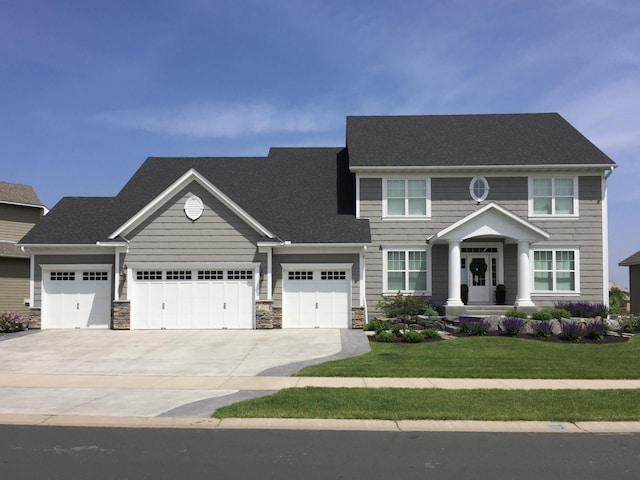 2915 Aspen Lake Dr NE, Blaine, MN 55449 - view of front of home featuring stone siding, a front yard, concrete driveway, and an attached garage