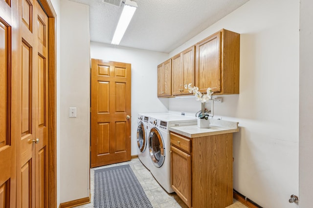 3621 Lansing Ave NE, Saint Michael, MN 55376 - laundry area featuring cabinet space, separate washer and dryer, and a textured ceiling