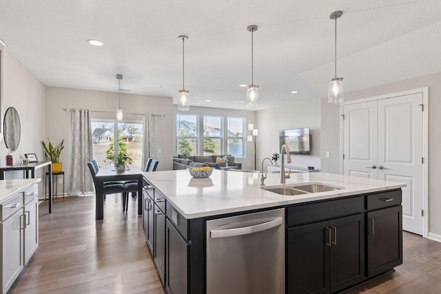 kitchen with a sink, recessed lighting, wood finished floors, dishwasher, and decorative light fixtures