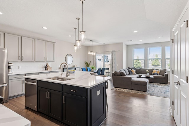 kitchen featuring a sink, stainless steel appliances, backsplash, dark wood-style floors, and recessed lighting