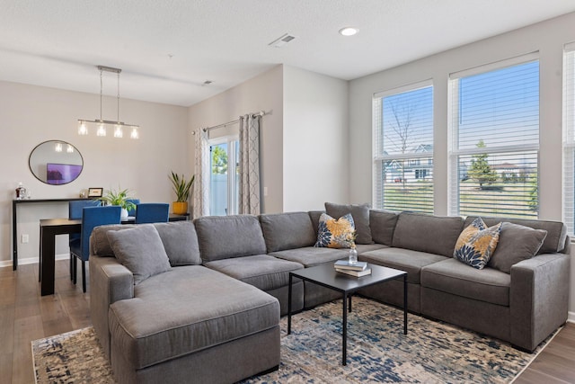 living room featuring recessed lighting, wood finished floors, visible vents, and baseboards