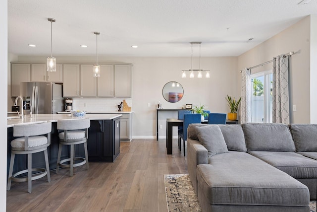 living area featuring baseboards, recessed lighting, and light wood-type flooring