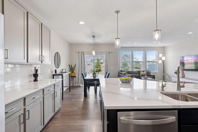 kitchen featuring recessed lighting, dishwasher, wood finished floors, and a sink