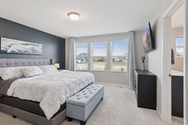 bedroom with light carpet, baseboards, a textured ceiling, and multiple windows
