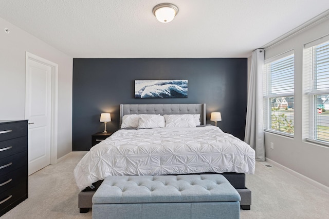 bedroom featuring baseboards and light colored carpet