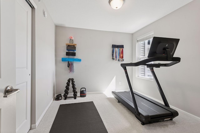 exercise room with carpet floors and baseboards
