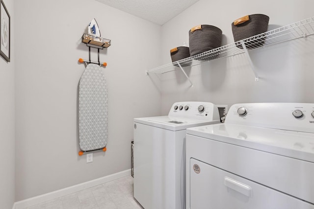 washroom featuring baseboards, washer and clothes dryer, and laundry area