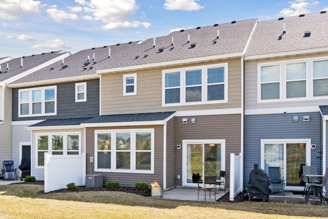 rear view of house with a patio area, a lawn, and central AC
