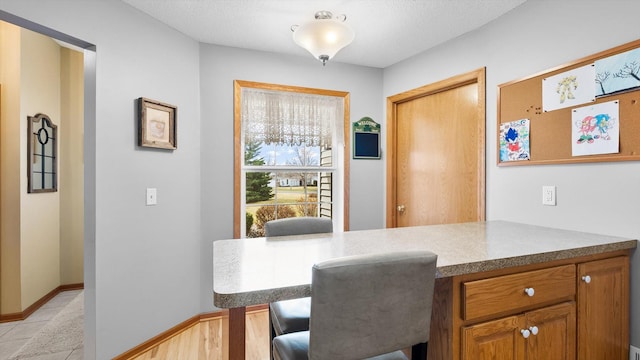 112 Sandpiper Cir, Hastings, MN 55033 - kitchen featuring a kitchen breakfast bar, brown cabinets, and baseboards