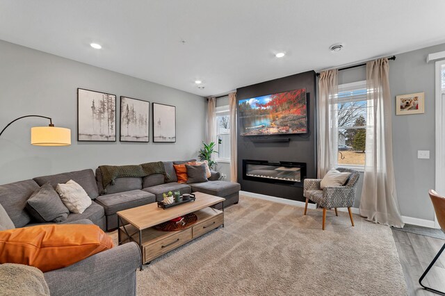 22962 Hazel Ln, Rogers, MN 55374 - living room with recessed lighting, baseboards, light wood-type flooring, and a glass covered fireplace