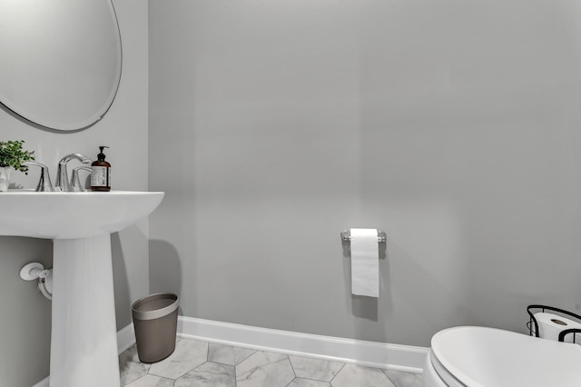 22962 Hazel Ln, Rogers, MN 55374 - bathroom featuring baseboards, marble finish flooring, and toilet