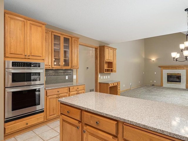 1844 Red Fox Rd, Eagan, MN 55122 - kitchen with double oven, glass insert cabinets, a chandelier, backsplash, and open floor plan