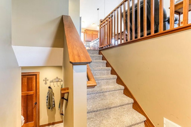 stairs featuring wood finished floors, baseboards, and visible vents
