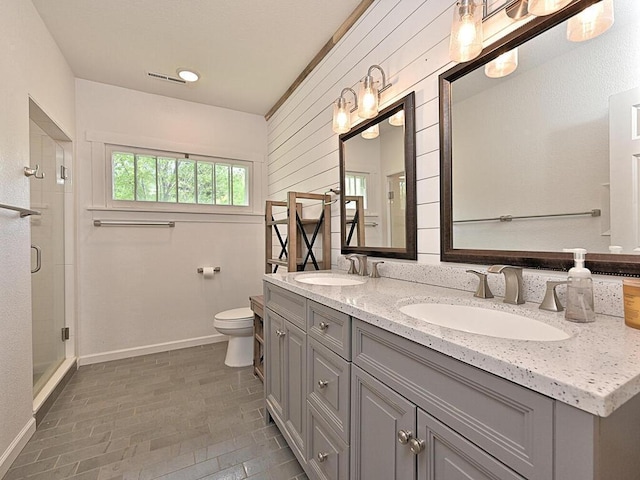 21327 Keyview Rd, Grand Rapids, MN 55744 - full bathroom with baseboards, toilet, a shower stall, and double vanity