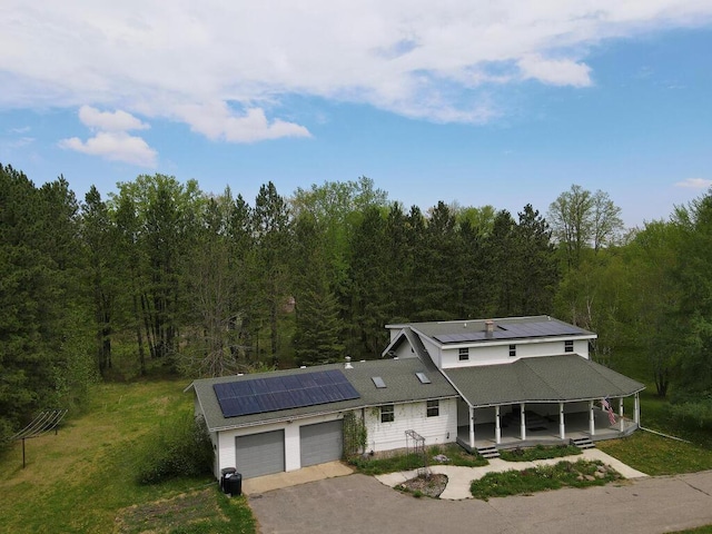 21327 Keyview Rd, Grand Rapids, MN 55744 - view of front facade featuring a garage, solar panels, asphalt driveway, and a forest view