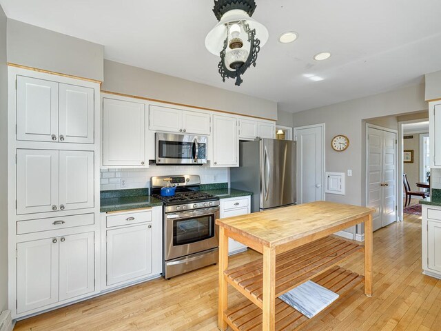 25 Benhill Rd, Saint Paul, MN 55105 - kitchen featuring appliances with stainless steel finishes, dark countertops, light wood-type flooring, backsplash, and recessed lighting