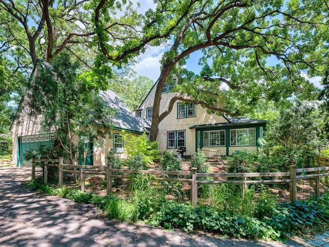 25 Benhill Rd, Saint Paul, MN 55105 - english style home with stucco siding, a fenced front yard, and a garage