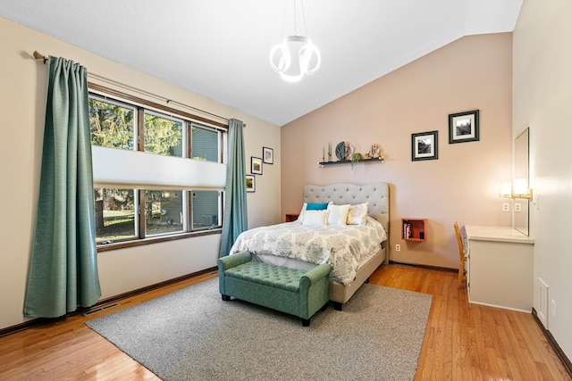 436 Bruns Ct, Vadnais Heights, MN 55127 - bedroom featuring light wood-style floors, a chandelier, baseboards, and high vaulted ceiling