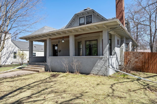 bungalow-style house with fence, a chimney, and stucco siding