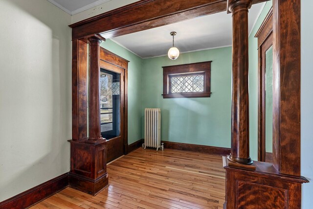 interior space featuring plenty of natural light, radiator, baseboards, and light wood-style flooring