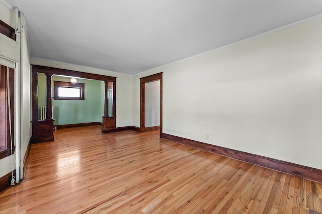 empty room featuring light wood-type flooring and baseboards