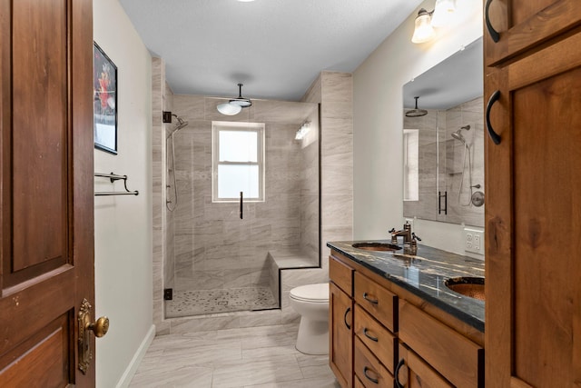 bathroom featuring marble finish floor, a sink, a shower stall, and toilet