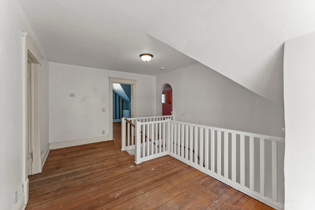 bonus room featuring wood-type flooring, arched walkways, and baseboards