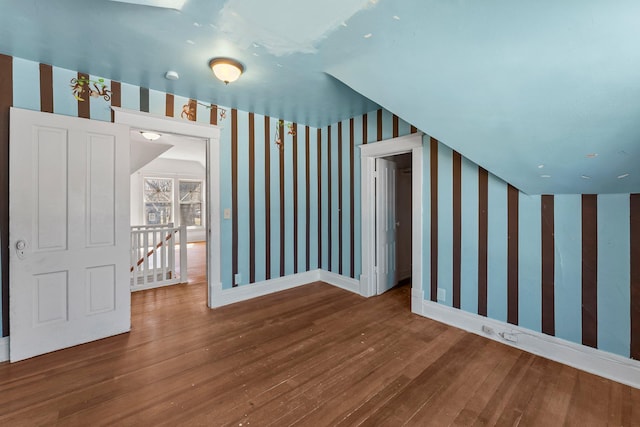 bonus room featuring baseboards, hardwood / wood-style floors, and wallpapered walls