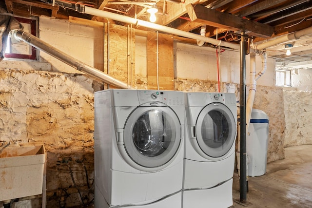 clothes washing area featuring washing machine and clothes dryer, a sink, and laundry area