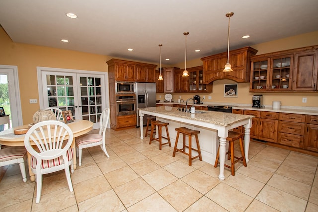 241 Cottonwood Cv, Lynd, MN 56157 - kitchen featuring brown cabinets, stainless steel appliances, recessed lighting, a center island with sink, and a kitchen breakfast bar