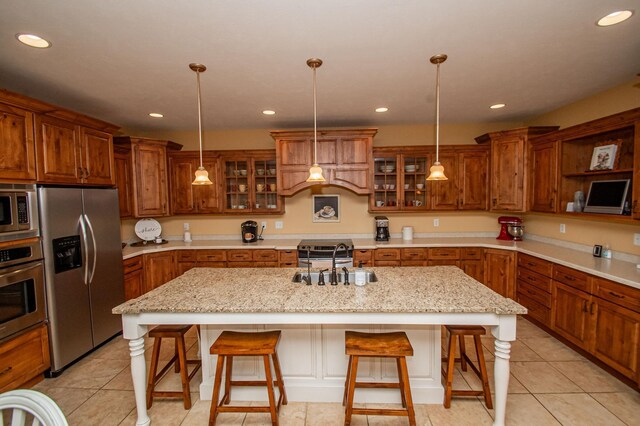 241 Cottonwood Cv, Lynd, MN 56157 - kitchen featuring a kitchen island with sink, stainless steel appliances, recessed lighting, a sink, and brown cabinetry