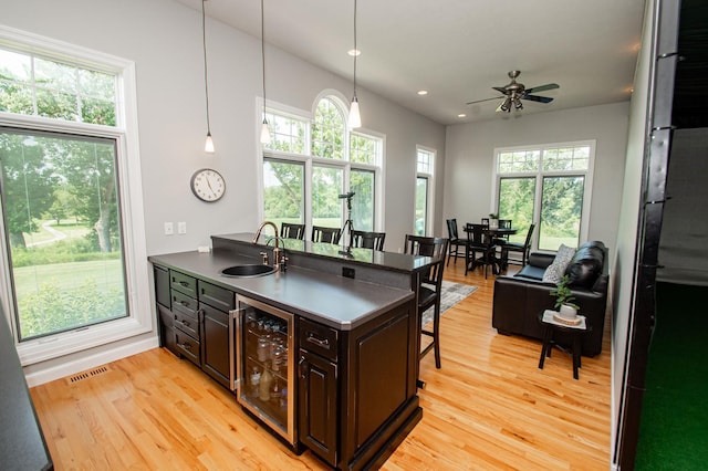 241 Cottonwood Cv, Lynd, MN 56157 - kitchen featuring a breakfast bar, a sink, beverage cooler, visible vents, and a peninsula