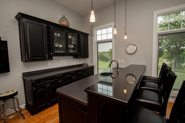 241 Cottonwood Cv, Lynd, MN 56157 - kitchen with dark countertops, light wood-style floors, dark cabinets, and a breakfast bar area